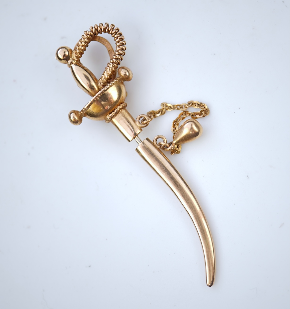 A gold and synthetic ruby jabot pin